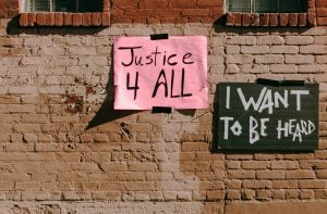 handwritten social justice signs on old building