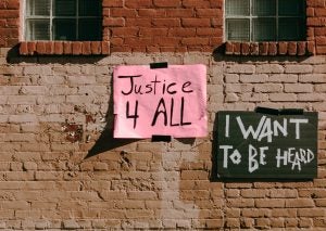 handwritten social justice signs on old building