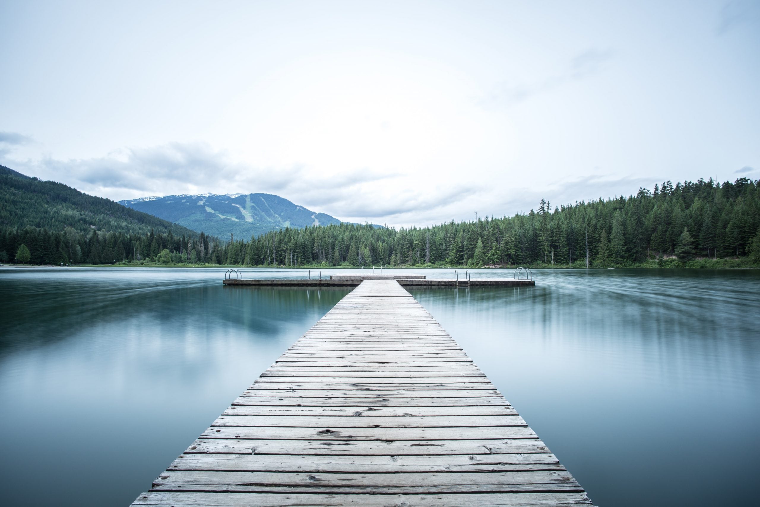 bridge over body of water by mountains