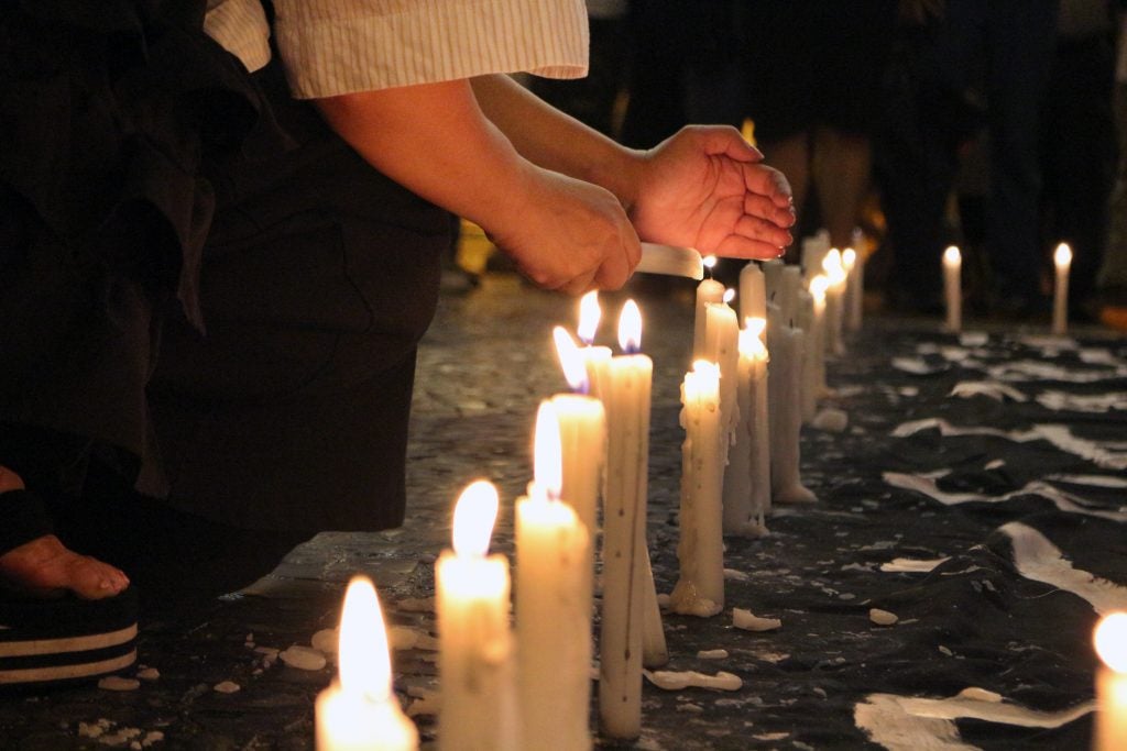 person lighting candles for vigil