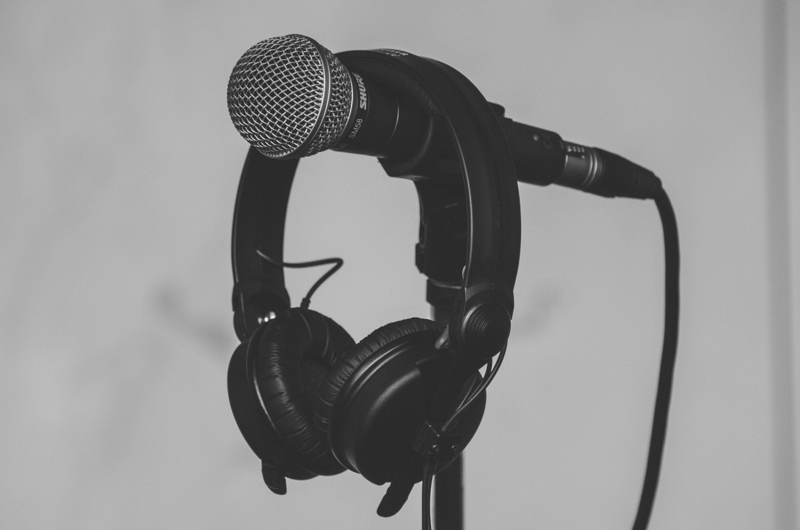 wired microphones with headphones hanging on it