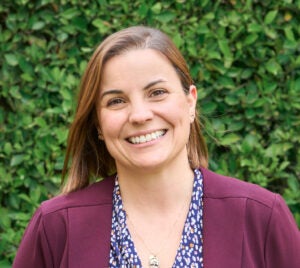 Portrait of Brianne Schuck in front of a green bush.