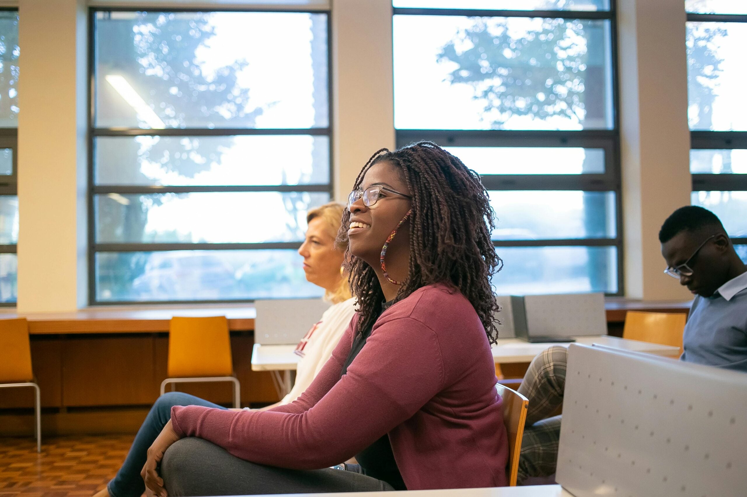 a diverse group of people in a conference space, listening to a presentation